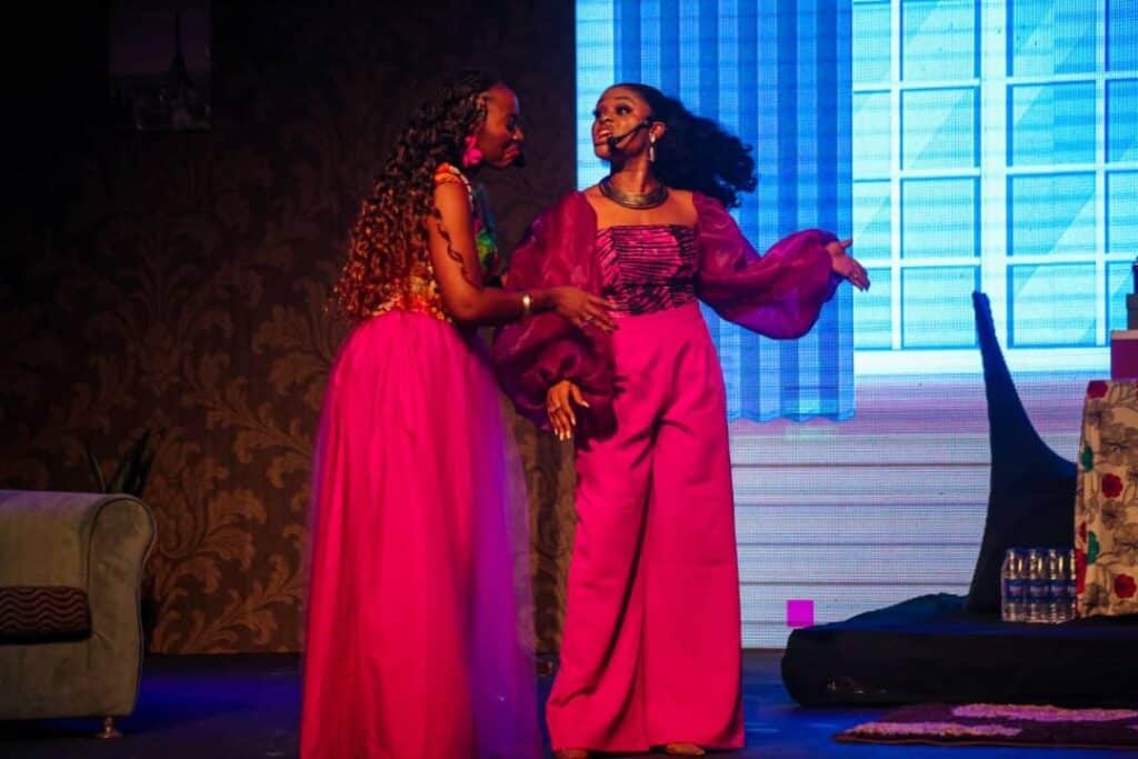 Two House of Naira performers in pink and gold